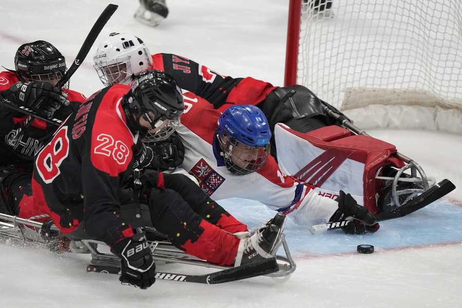Czech Republic's Alex Ohar, center, battles for the puck against China's Tian Jintao during their para ice hockey match at the 2022 Winter Paralympics, Sunday, March 6, 2022, in Beijing.