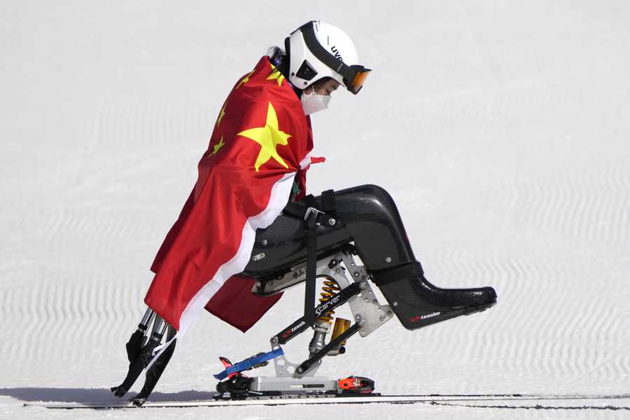 Zhang Wenjing of China leaves after the flower ceremony in the women's super G, sitting, at the 2022 Winter Paralympics, Sunday, March 6, 2022, in the Yanqing district of Beijing.