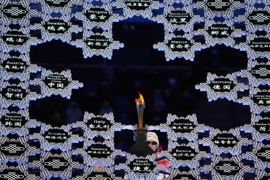Torchbearer and former Chinese Paralympian Li Duan lights the Paralympic flame during the opening ceremony at the 2022 Winter Paralympics, Friday, March 4, 2022, in Beijing.
