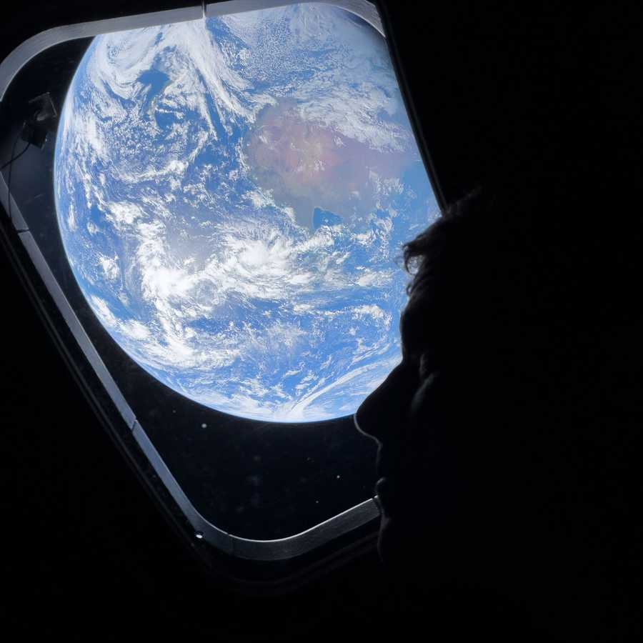Artemis II commander Reid Wiseman looks out the window at Earth.