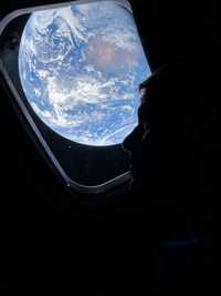 Artemis II commander Reid Wiseman looks out the window at Earth.