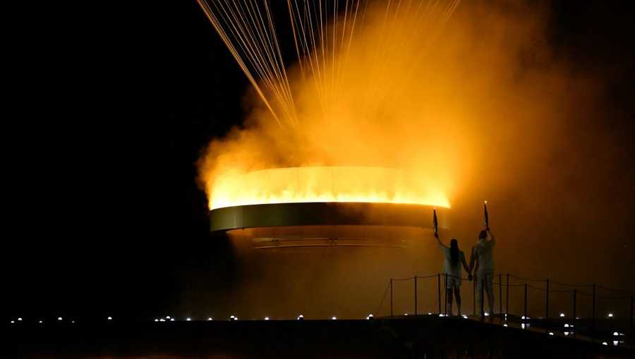 The cauldron, with the Olympic flame lit, lifts off while attached to a balloon as the torchbearers French former sprinter Marie-Jose Perec and French judoka Teddy Riner stand in front during the opening ceremony of the Paris 2024 Olympic Games at the Jardin des Tuileries (Tuileries Garden) in Paris on July 26, 2024. (Photo by MOHD RASFAN / AFP) (Photo by MOHD RASFAN/AFP via Getty Images)
