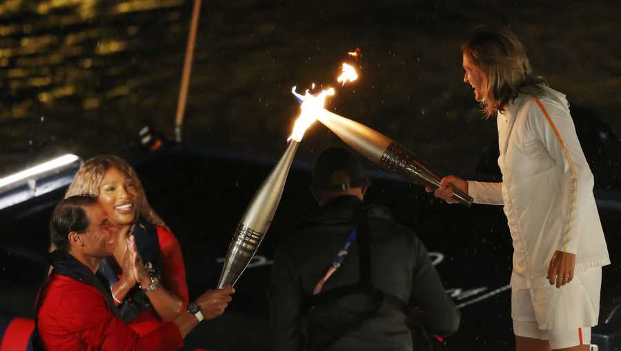 PARIS, FRANCE - JULY 26: Tennis Player Rafael Nadal of Team Spain, 14 Time French Open Winner, hands over the torch to Former French Tennis Player Amelie Mauresmo during the opening ceremony of the Olympic Games Paris 2024 on July 26, 2024 in Paris, France. (Photo by Alex Davidson/Getty Images)
