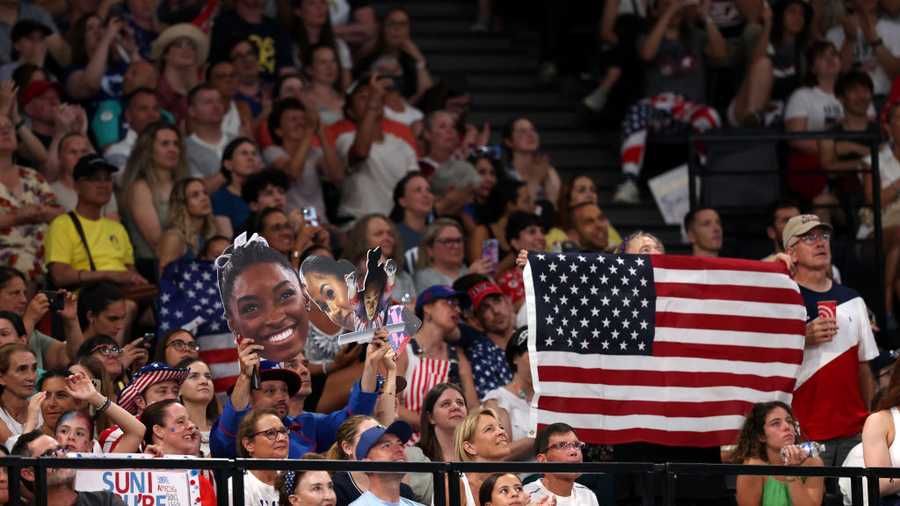 PARIS, FRANCE - JULY 30: Fans of Team United States cheer and hold signs during the Artistic Gymnastics Women&apos;s Team Final on day four of the Olympic Games Paris 2024 at Bercy Arena on July 30, 2024 in Paris, France. (Photo by Jamie Squire/Getty Images)