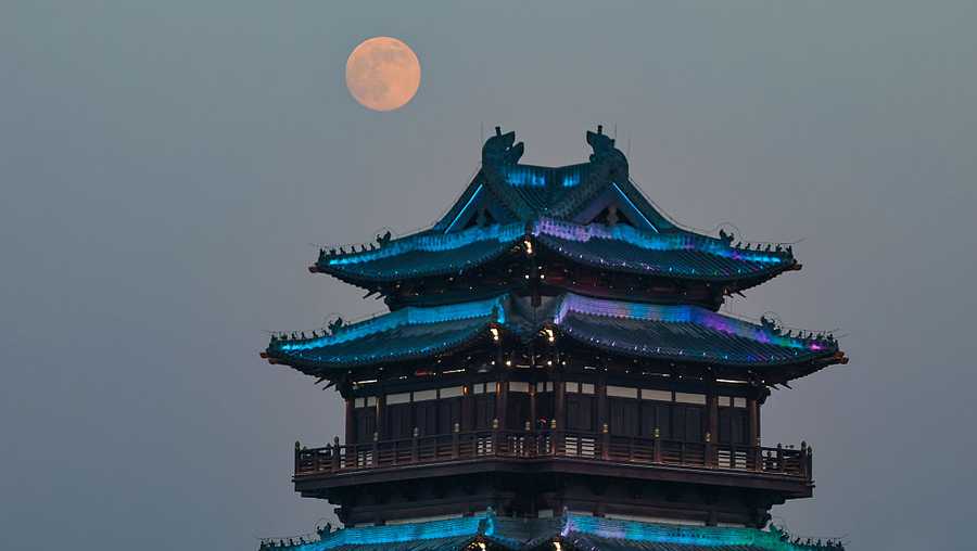 The supermoon appears above the Garden Expo Park in Lianyungang City, Jiangsu Province, China, on December 4, 2025. (Photo by Costfoto/NurPhoto via Getty Images)