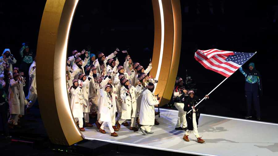Flagbearer Erin Jackson of Team United States enters the athlete parade with her team during the opening ceremony of the 2026 Milan Cortina Winter Olympics at San Siro Stadium.