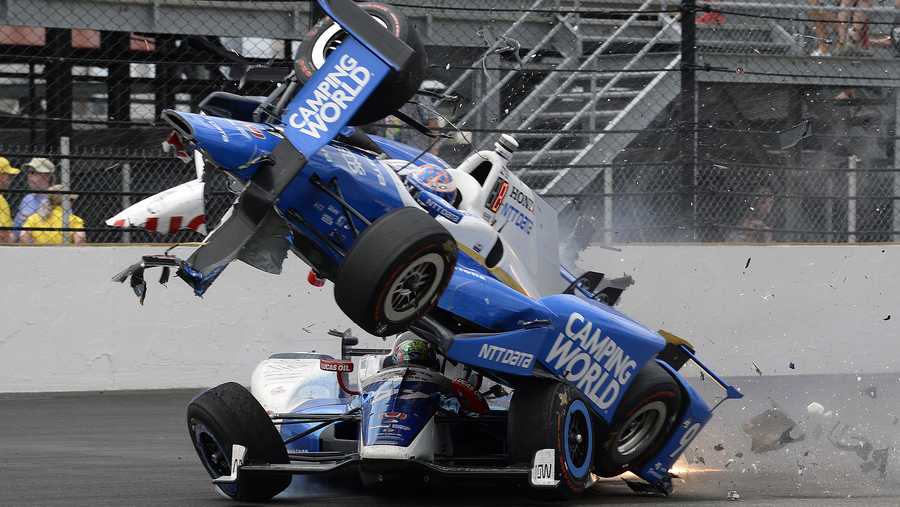 The car driven by Scott Dixon, of New Zealand, goes over the top of Jay Howard, of England, in the first turn during the running of the Indianapolis 500 auto race at Indianapolis Motor Speedway, Sunday, May 28, 2017, in Indianapolis. (AP Photo/Marty Seppala)