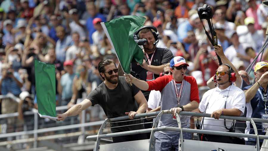 Actor Jake Gyllenhaal and Boston bombing survivor Jeff Bauman, left, wave the green flags to start the 101st running of the Indianapolis 500 auto race at Indianapolis Motor Speedway, Sunday, May 28, 2017 in Indianapolis. (AP Photo/Michael Conroy) 