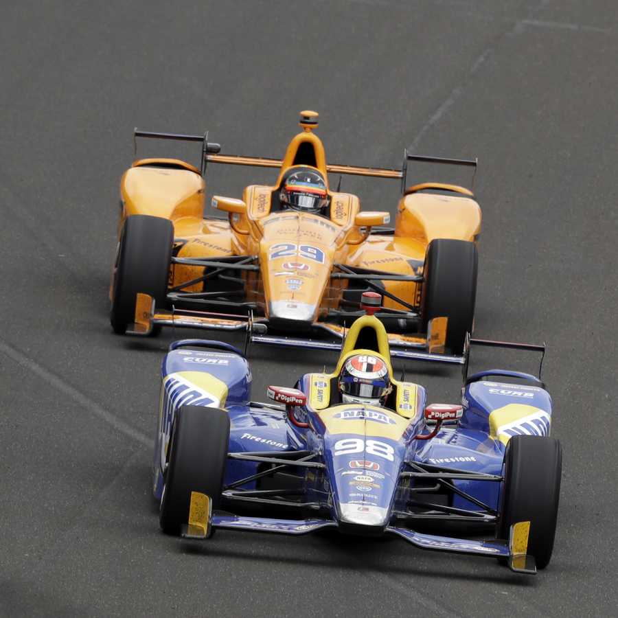Alexander Rossi leads Fernando Alonso, of Spain, into the first turn during the running of the Indianapolis 500 auto race at Indianapolis Motor Speedway, Sunday, May 28, 2017, in Indianapolis. 