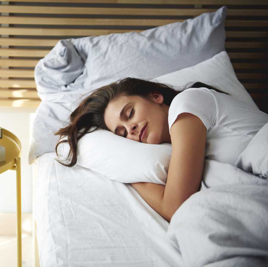 Portrait of woman sleeping in bed by daylight